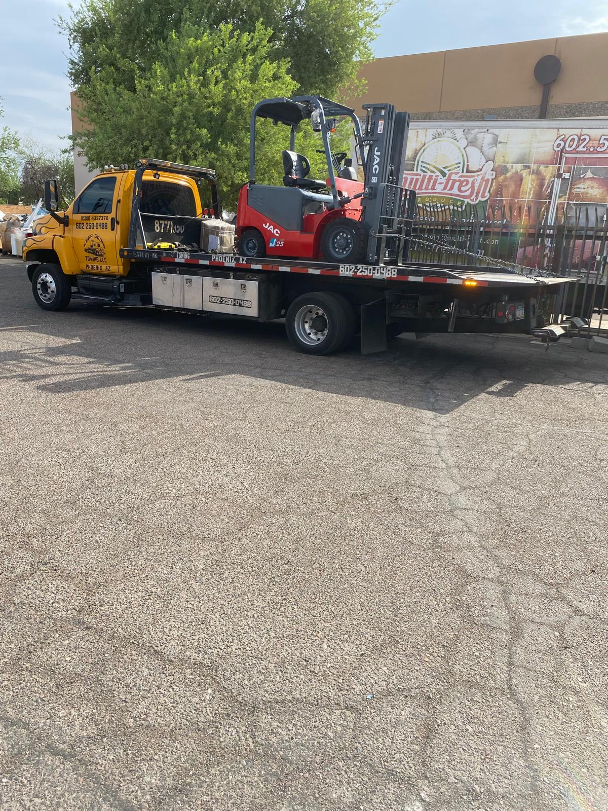 Forklift secured on Keep Going Towing flatbed truck